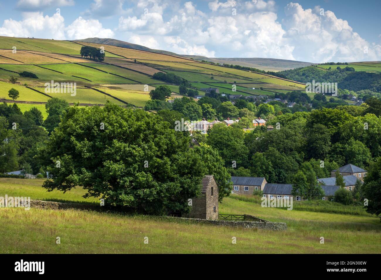 A view over the village of Hayfield in High Peak, Derbyshire. The copse of trees known as Twenty Trees can be seen on the distant hillside. Stock Photo