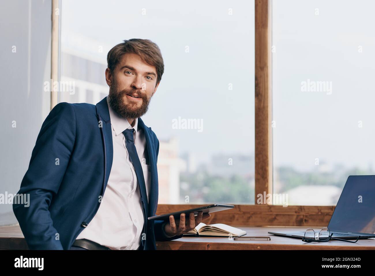man in a suit near the window with a laptop communication Stock Photo ...