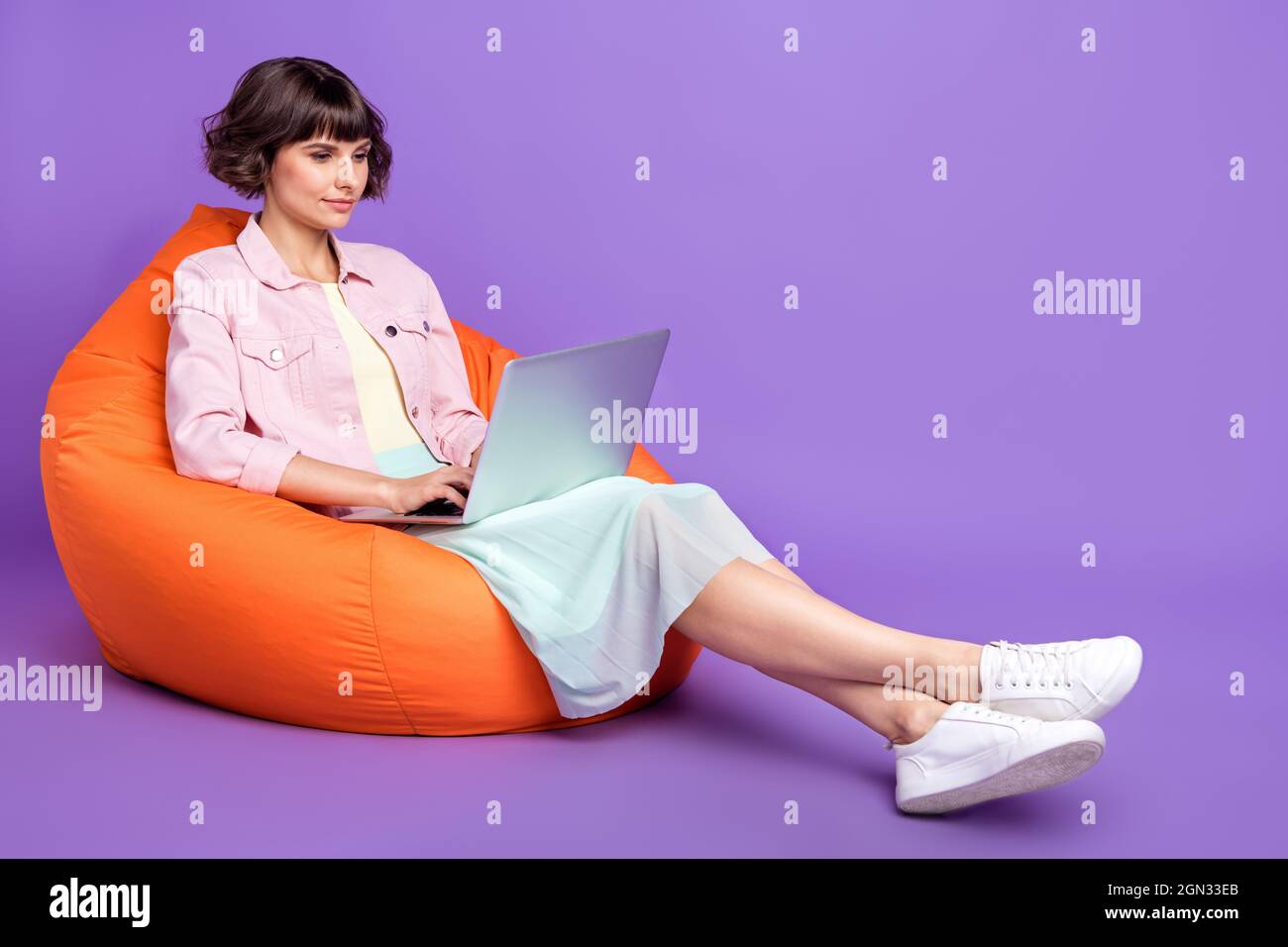 Full size photo of focused charming young woman sit chair hold laptop