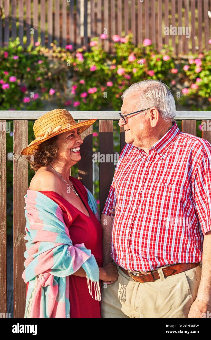 Happy old couple enjoying walk together standing looking at each other Stock Photo