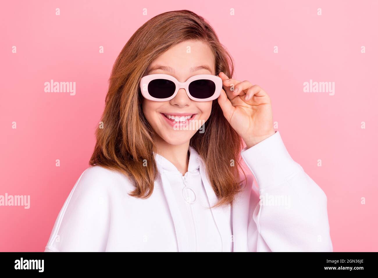 Photo portrait little girl in white hoodie smiling wearing sunglass