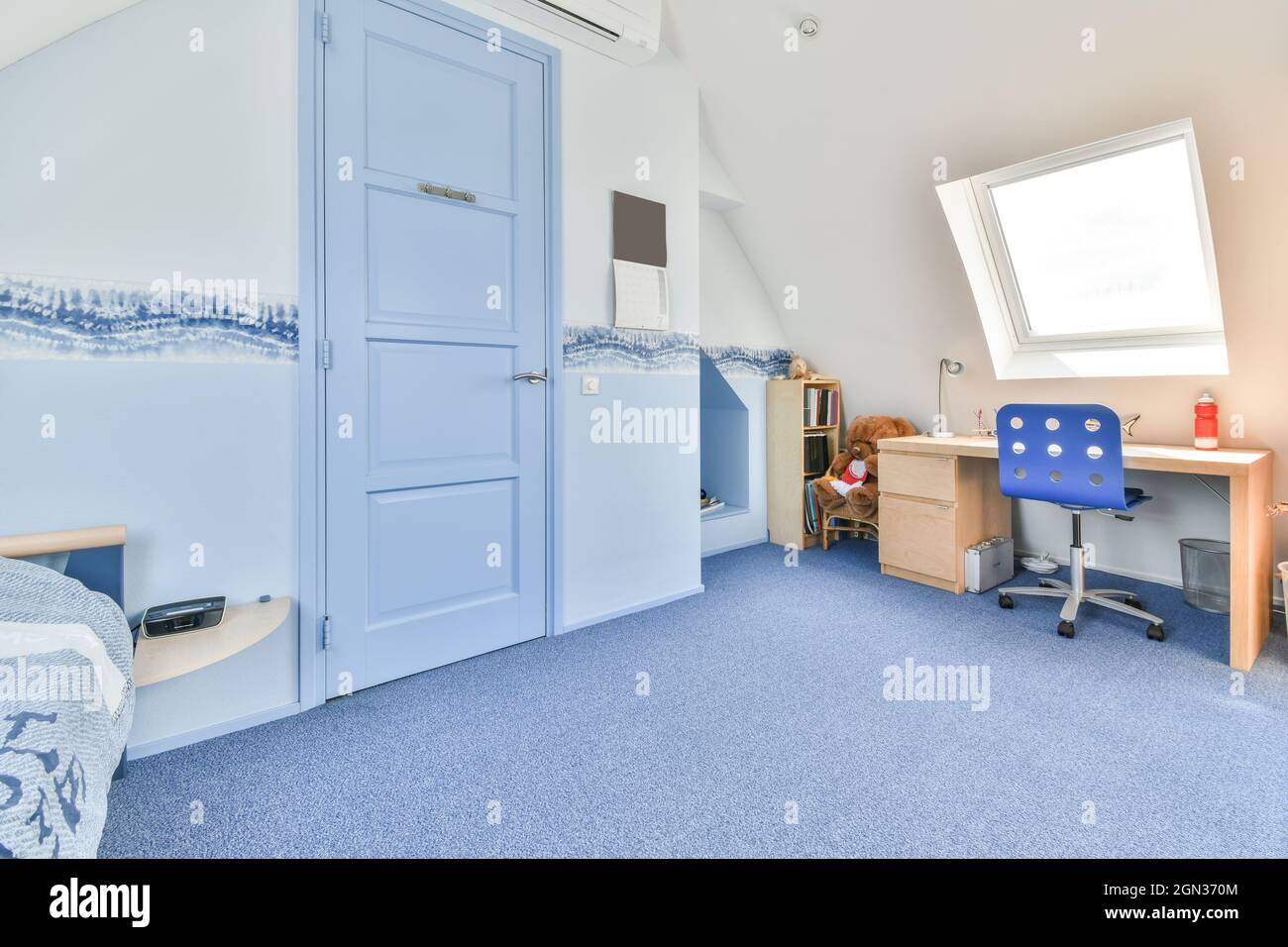 Contemporary bedroom interior with door between bed and desk under