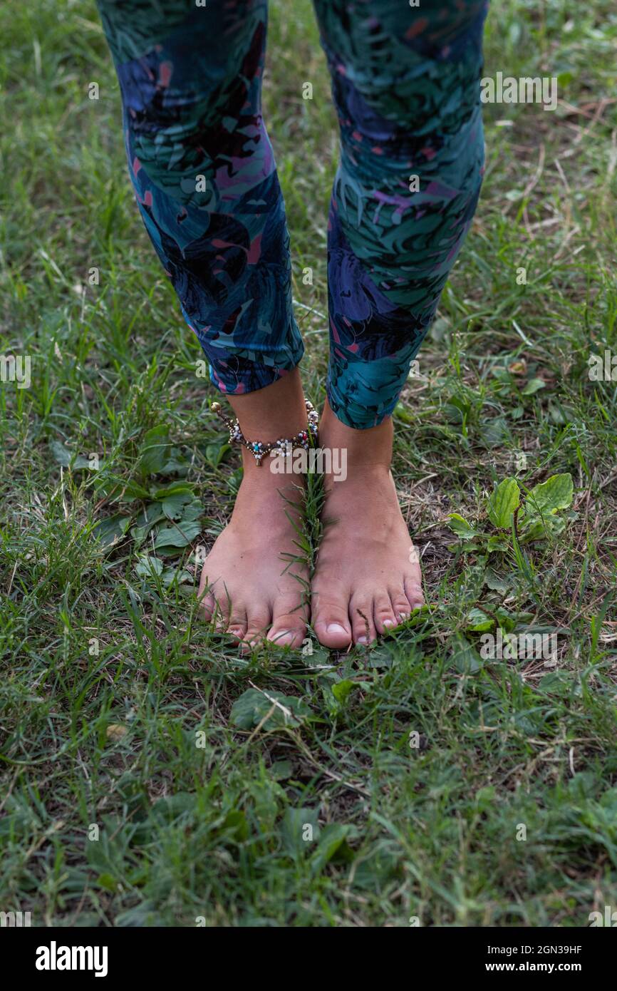 From above of crop unrecognizable barefoot female in leggings standing ...