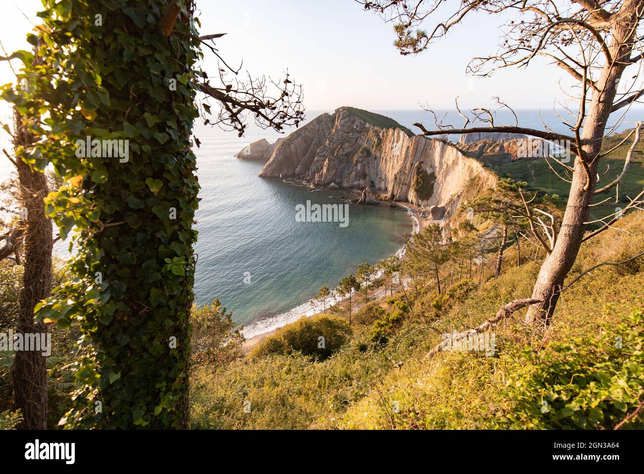 Scenic view of cliff in rippled ocean with horizon under light sky in Asturias Spain Stock Photo