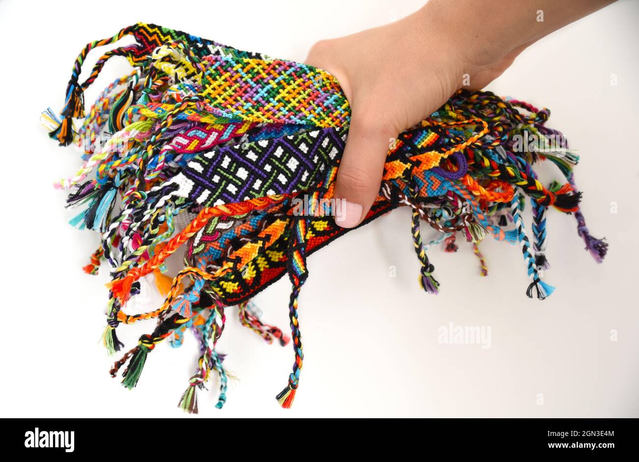 Female hand holding many woven multi colored DIY friendship