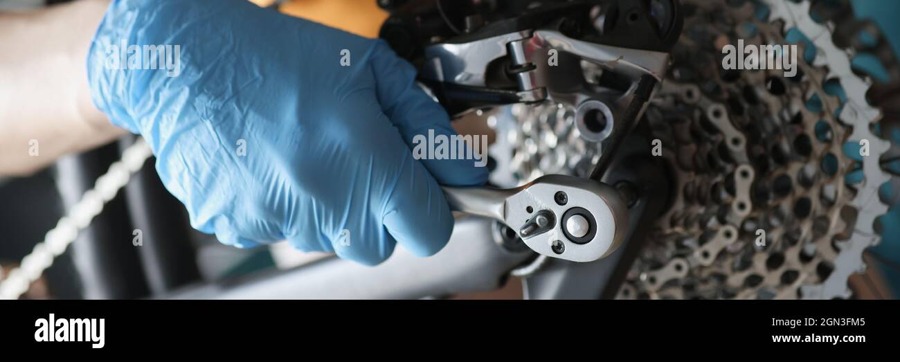 Repairman fixing bicycle wheel using metal tools closeup Stock Photo