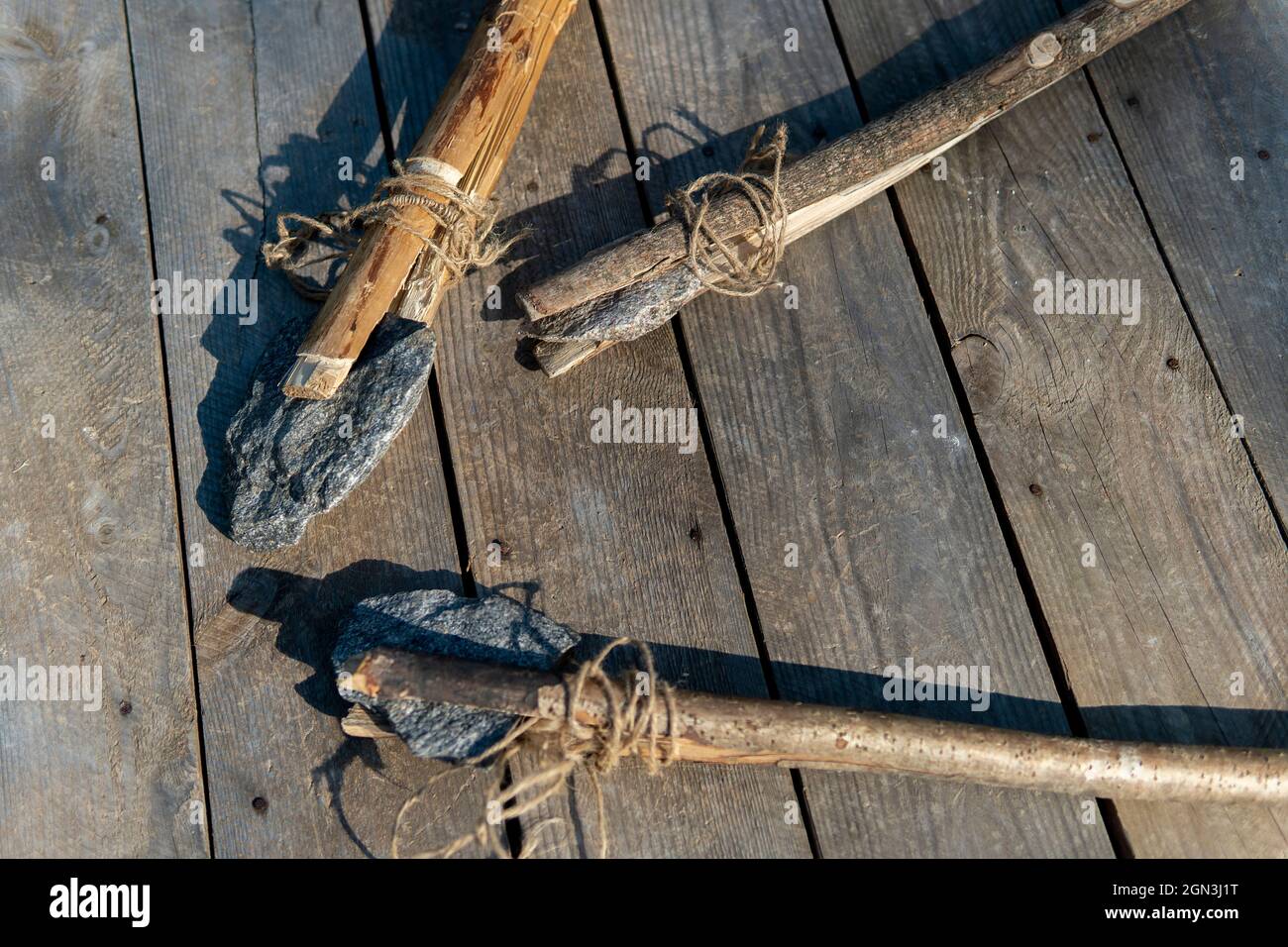 ancient stone axe and stone spear on a wooden background. Stock Photo