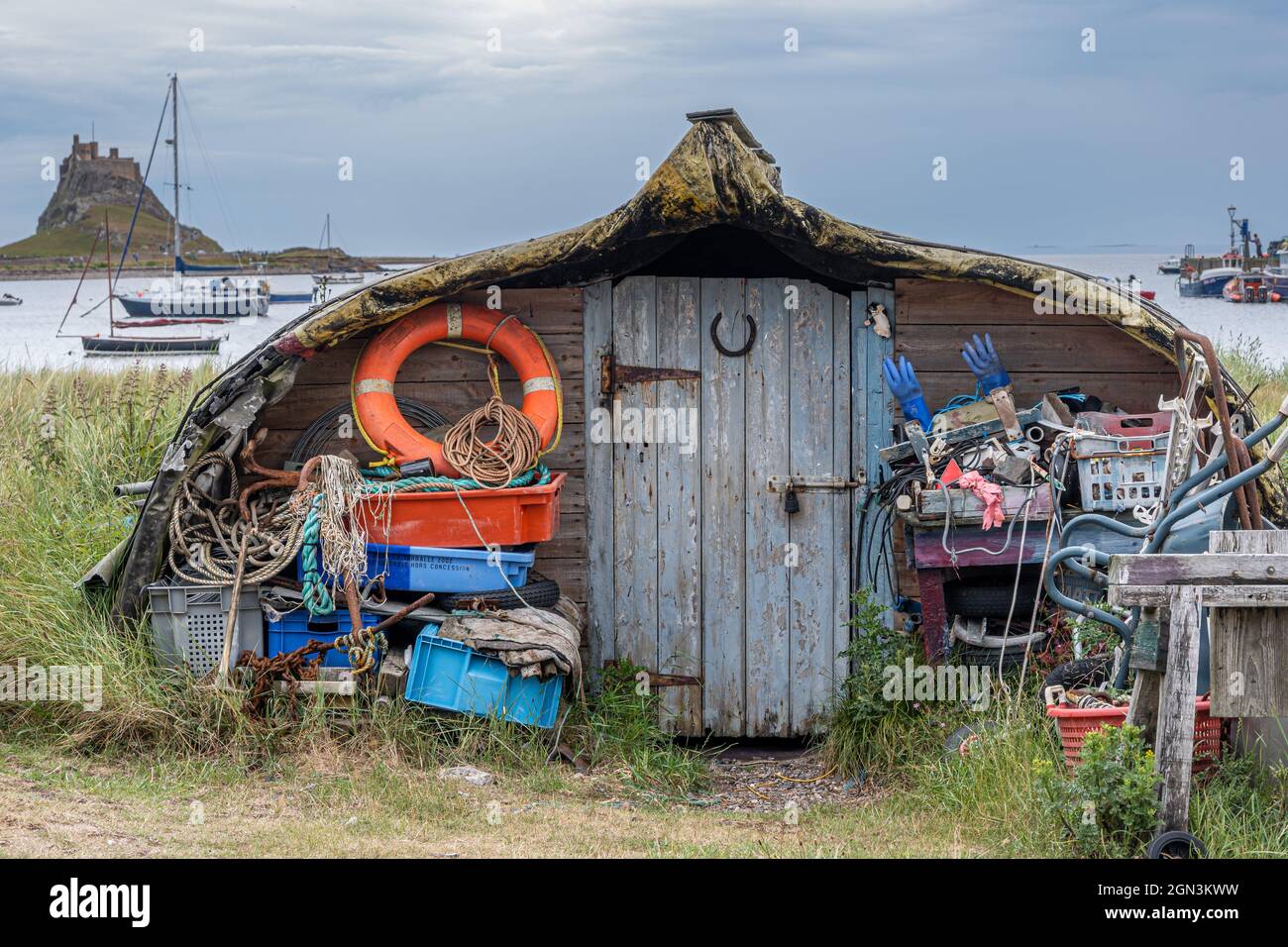 Upturned boat repurposed as a storage shed around the harbour on Lindisfarne Stock Photo