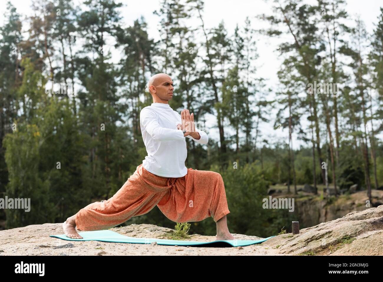 buddhist in harem pants practicing yoga in warrior pose outdoors Stock Photo Alamy