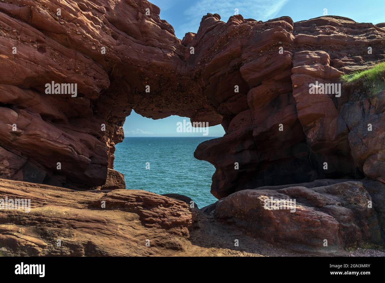 The Needle's E'e (Eye) is a natural arch formed by coastal erosion in the old red sandstone rocks at Seaton Cliffs near Arbroath, Scotland. Stock Photo