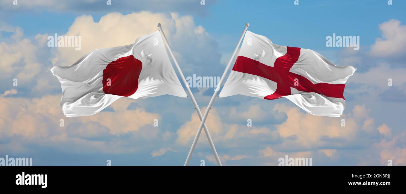 flags of Japan and England waving in the wind on flagpoles against sky ...