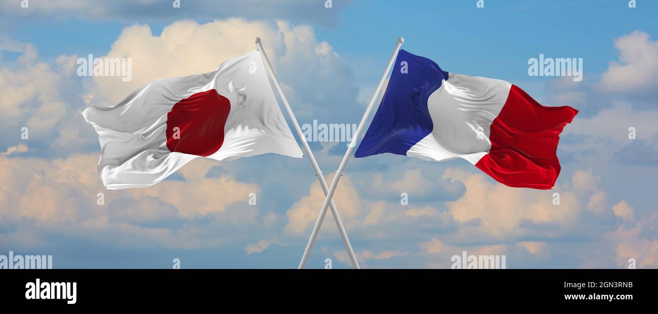 flags of Japan and France waving in the wind on flagpoles against sky ...