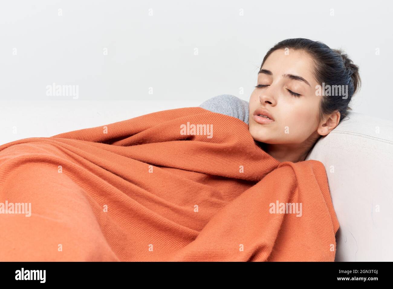 woman lies on the bed covered with a blanket cold treatment Stock Photo