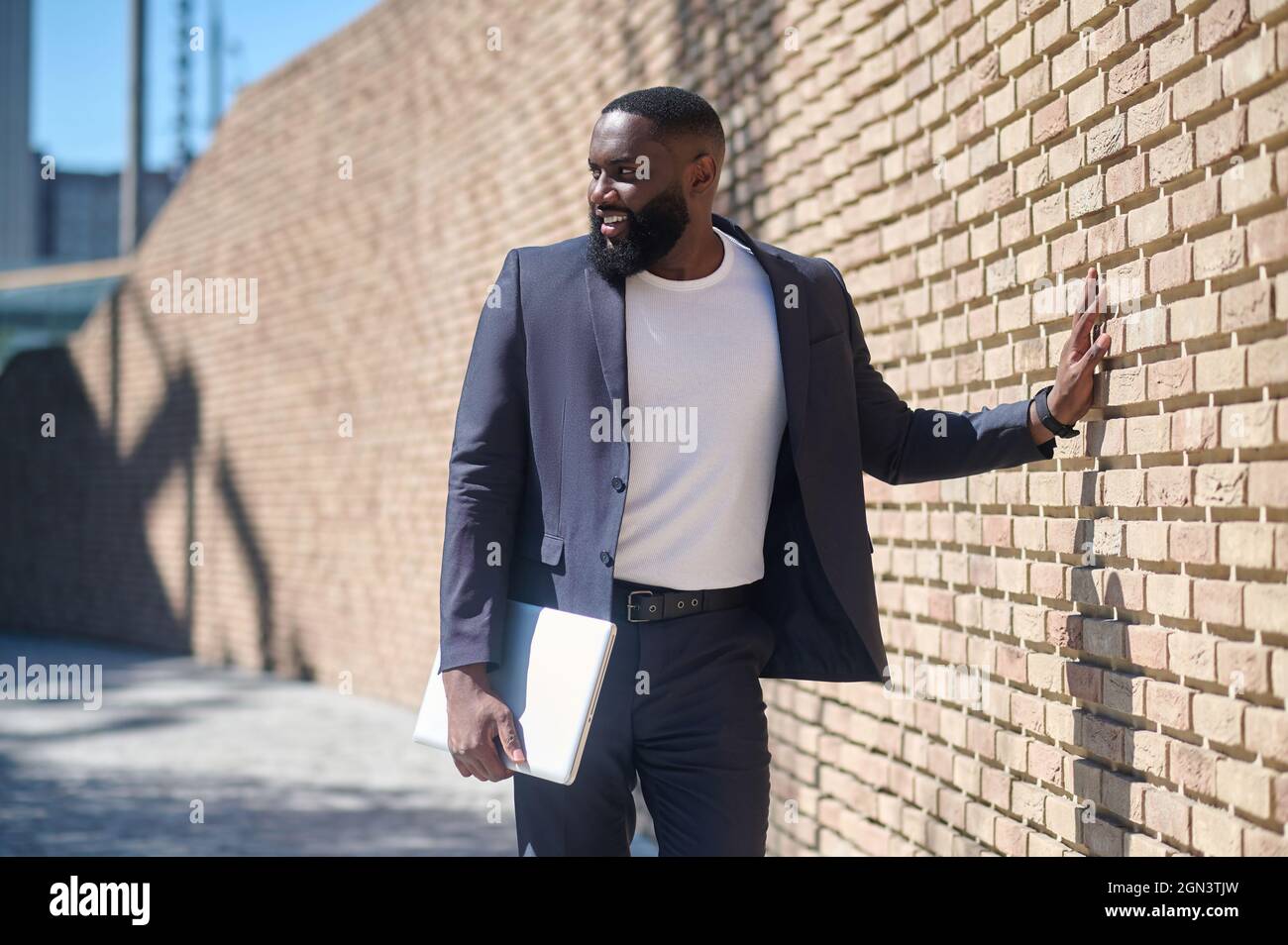 An african american man in a suit standing near the brick wall Stock ...