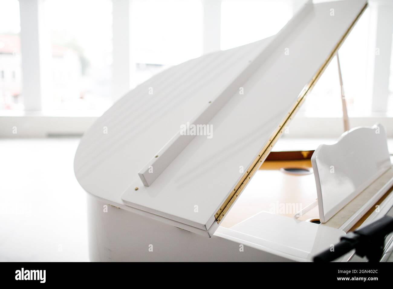 white Grand piano in a beautiful light interior Stock Photo - Alamy