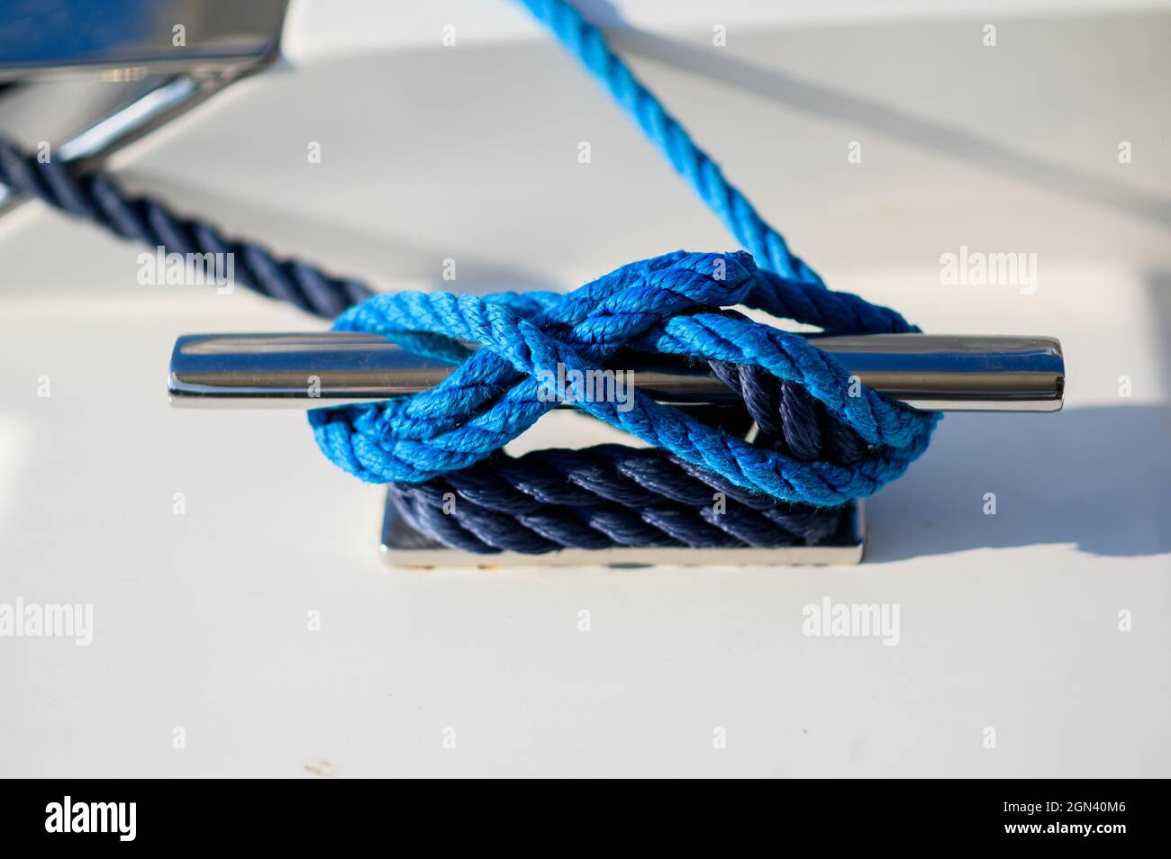 Mooring rope. Blue mooring rope tied around steel anchor on boat or ship Stock Photo