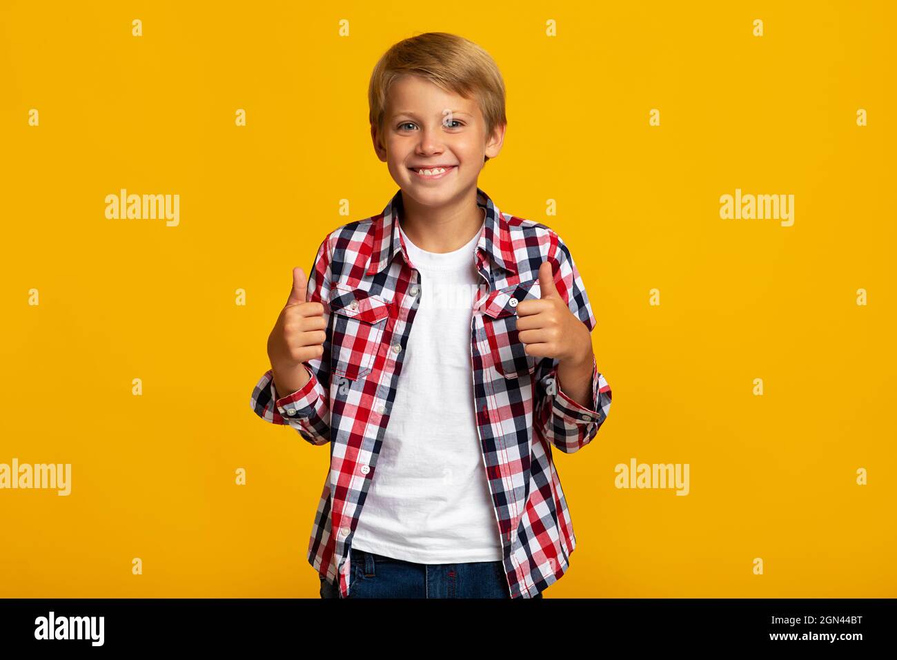 Cheerful young teen boy student show thumbs up sign recommends something for school Stock Photo