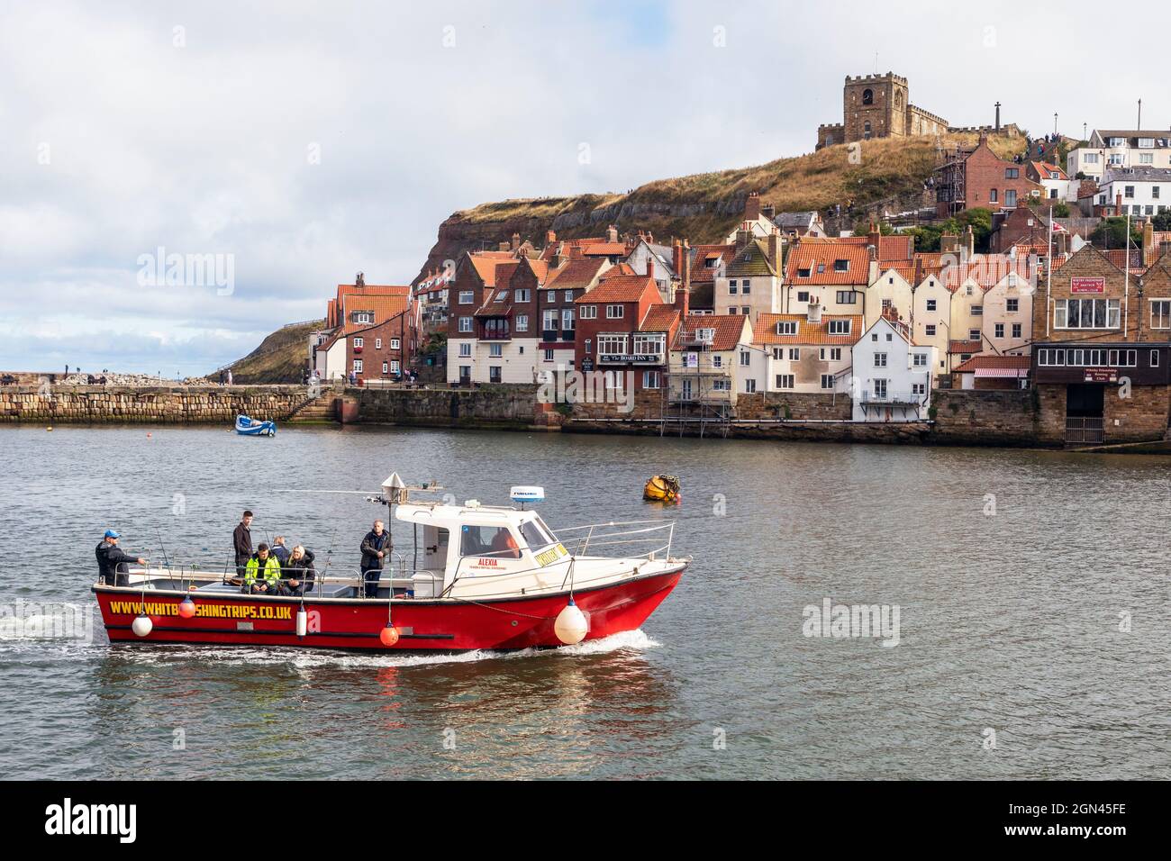 small motor boat used to take tourists on fishing trips entering the harbour at Whitby, on the River Esk, Redcar and Cleveland district, Yorkshire Stock Photo