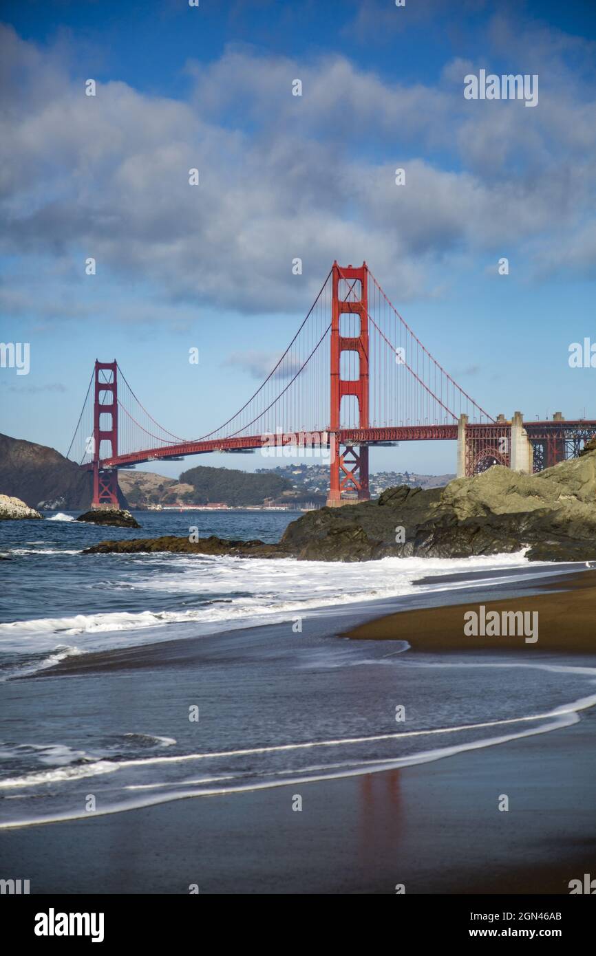 Vertical shot of a golden gate bridge over the foamy water under a ...