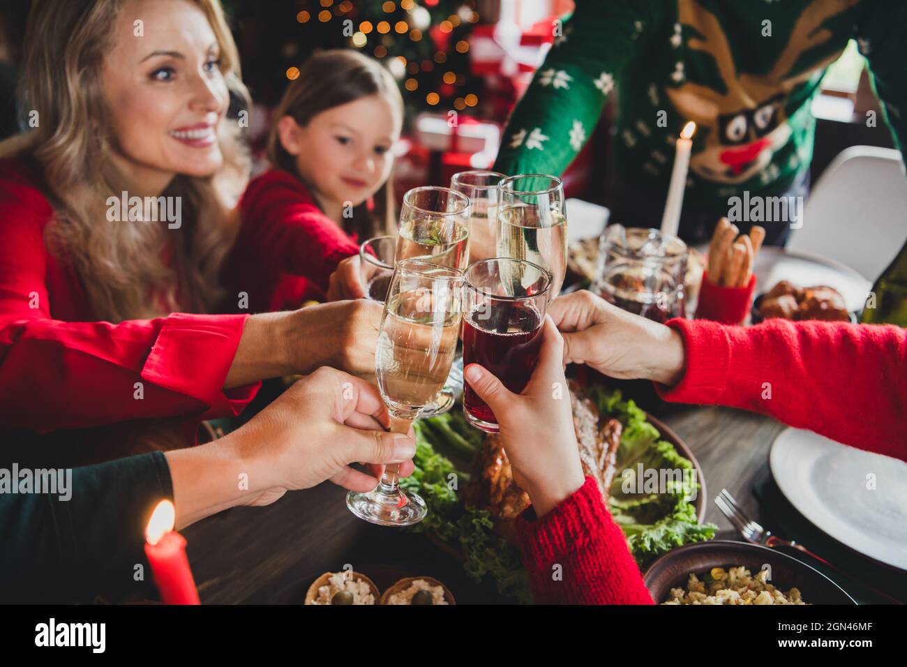 Top view of family celebrating holidays together drinking champagne at festive table eating tasty dishes Stock Photo
