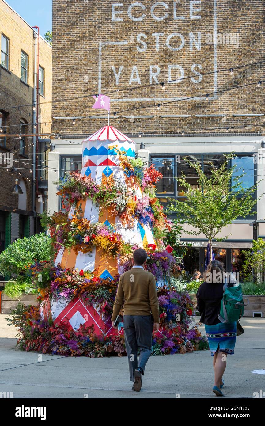 London, UK.  22 September 2021.  A helter-skelter style flower installation Eccleston Yard in Belgravia, part of Belgravia in Bloom, whose theme this year is ‘Floral Fairground’.   The local floral installations coincide with the postponed RHS Chelsea Flower Show, 20th – 26th September 2021. Credit: Stephen Chung / Alamy Live News Stock Photo