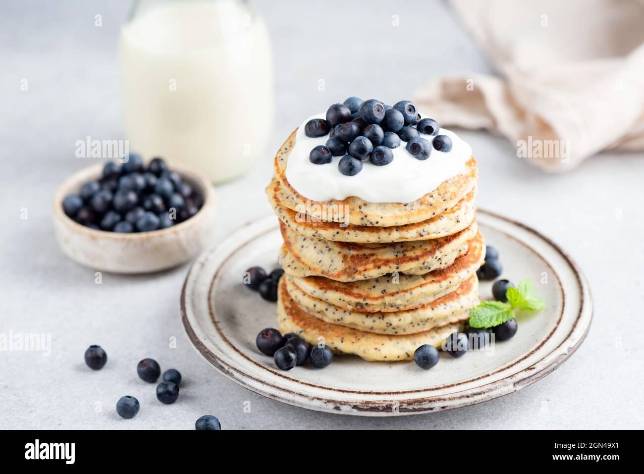 Stack of lemon poppy seed pancakes topped with yogurt and blueberries. Healthy breakfast food, low sugar pancakes Stock Photo