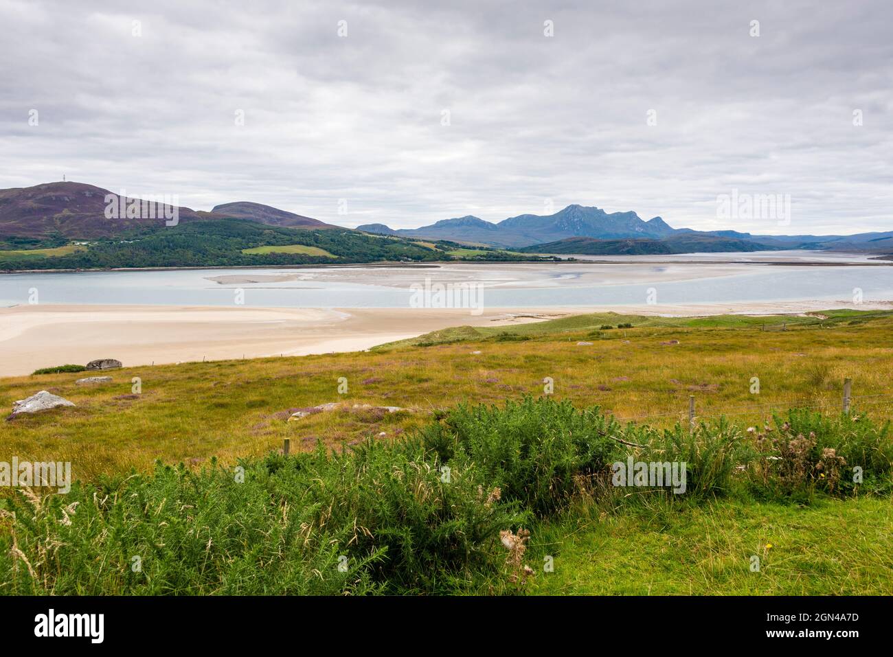 On the horizon the jagged peaks of Ben Loyal rise behind waters and sandflats of the Kyle of Tongue seen from Midtown near the NC500, north Scotland. Stock Photo