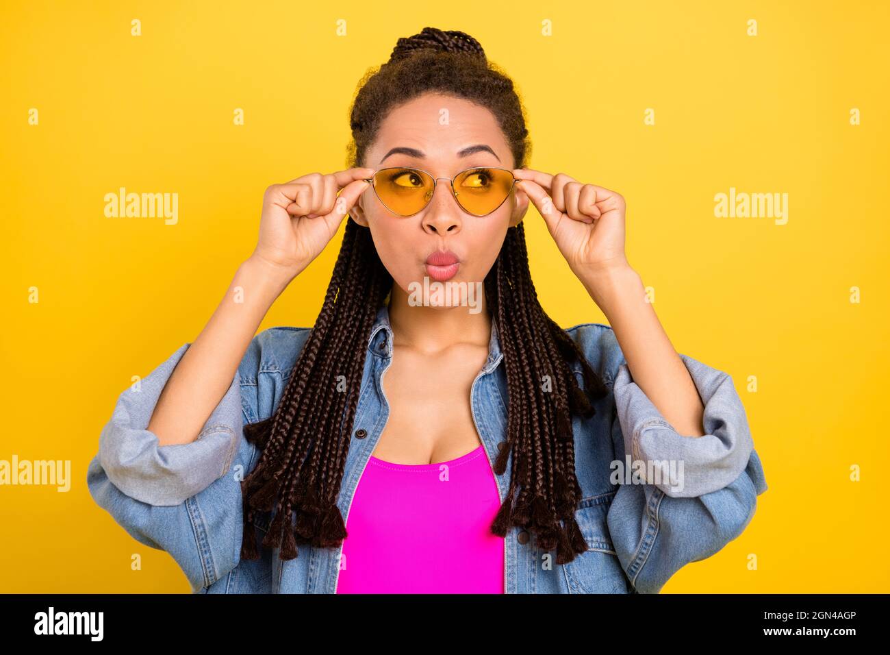 Photo of young african girl pouted lips hands touch glasses curious look empty space isolated over yellow color background Stock Photo