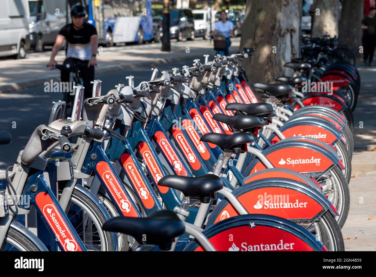 Santander Cycles in a docking station in Westminster, London, UK. Public bicycle hire scheme in the City of London, with cyclists in cycle lane Stock Photo