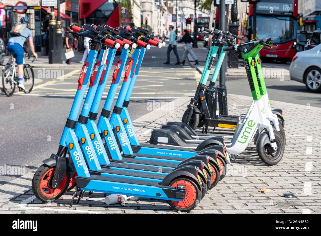 Lime and Dott e scooters for hire in London, UK, with buses and car.  Cyclist and people walking. Busy city scene with electric scooters on  street Stock Photo - Alamy