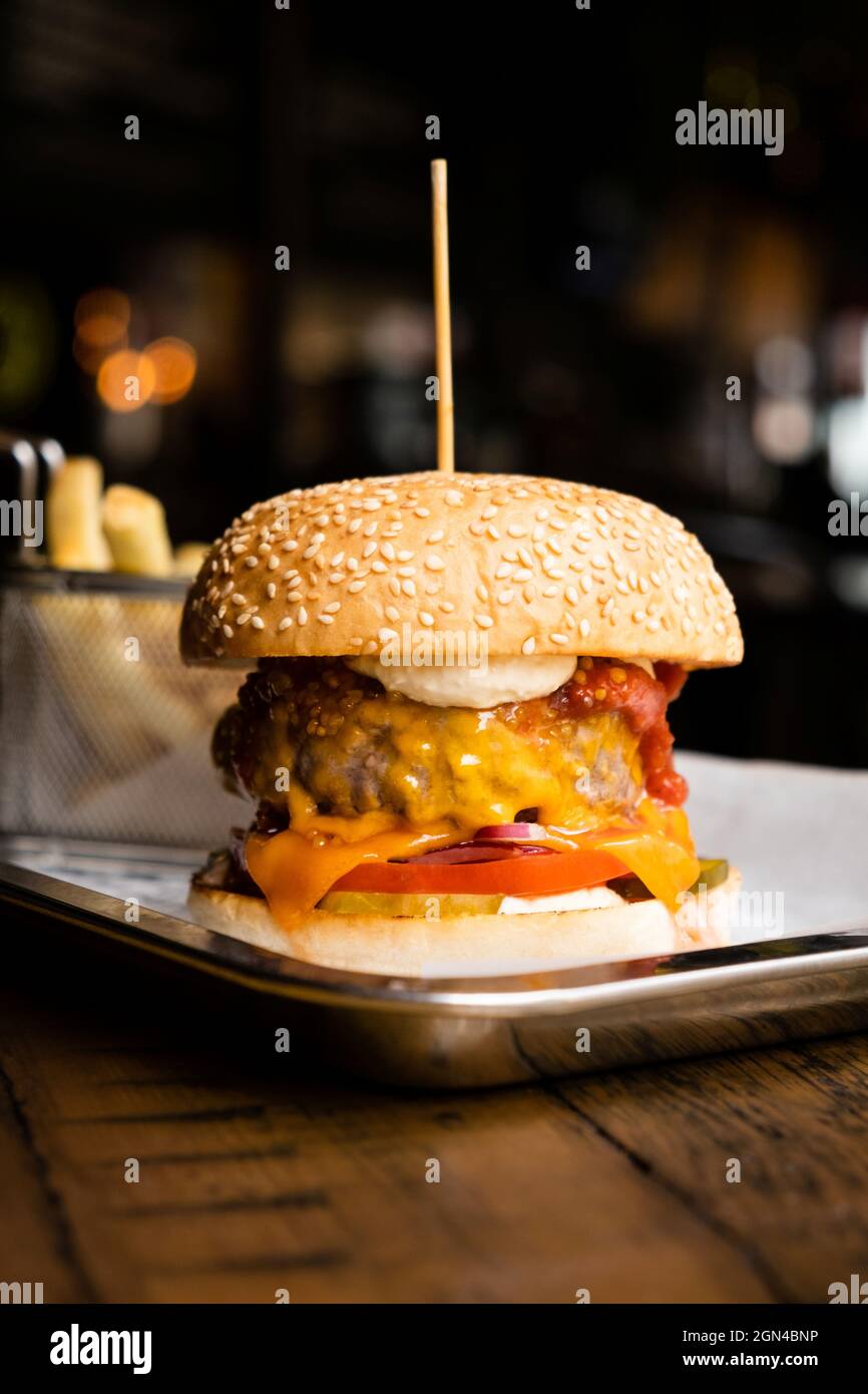 Juicy Cheeseburger On Serving Tray On Wooden Table Stock Photo