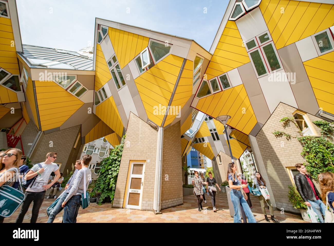 Rotterdam Netherlands - August 22 2021; Yellow exteriors and shapes and propped up look of cubic houses a popular tourist attraction in city. with blu Stock Photo