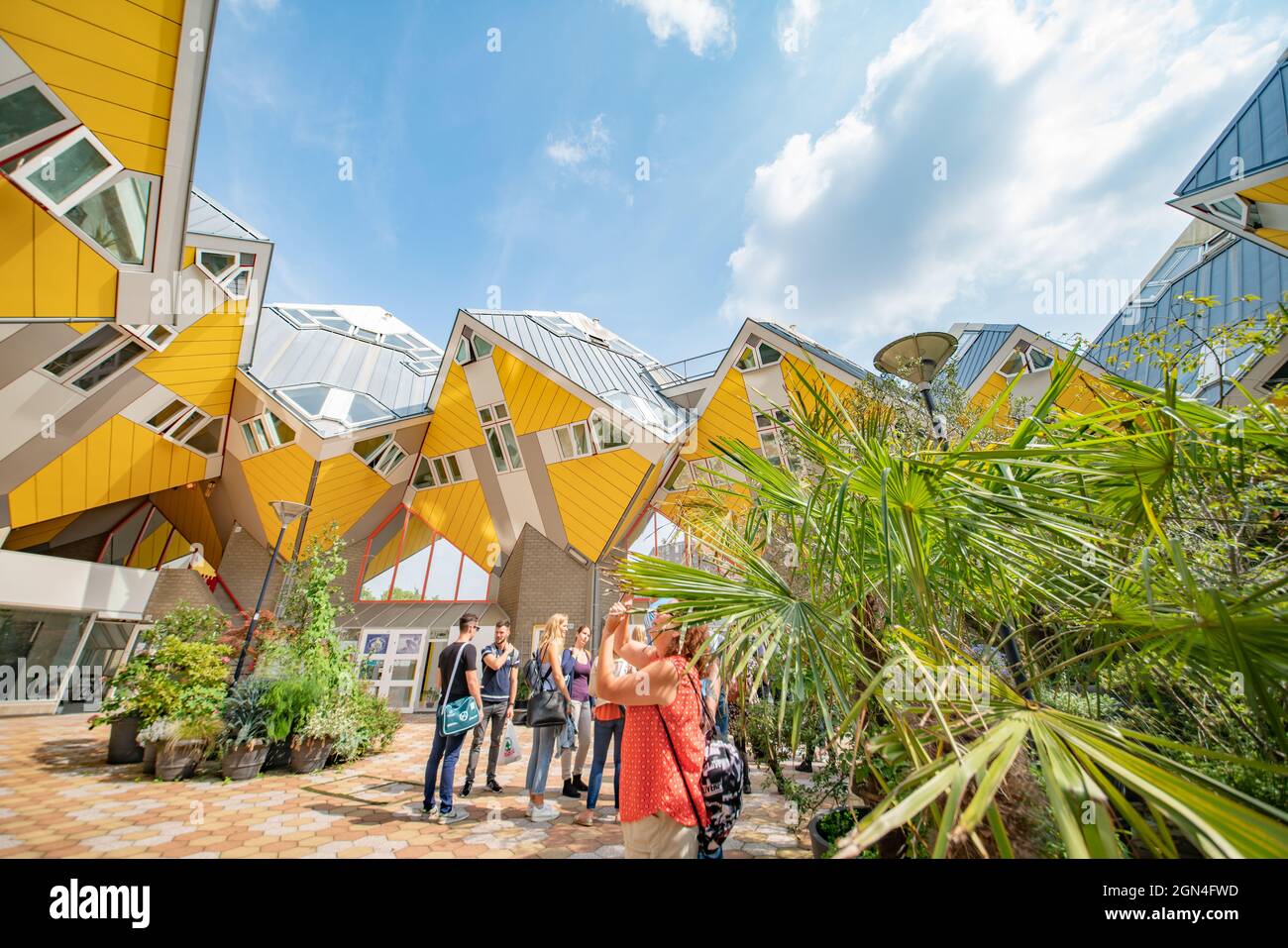Rotterdam Netherlands - August 22 2021; Yellow exteriors and shapes and propped up look of cubic houses a popular tourist attraction in city. with blu Stock Photo