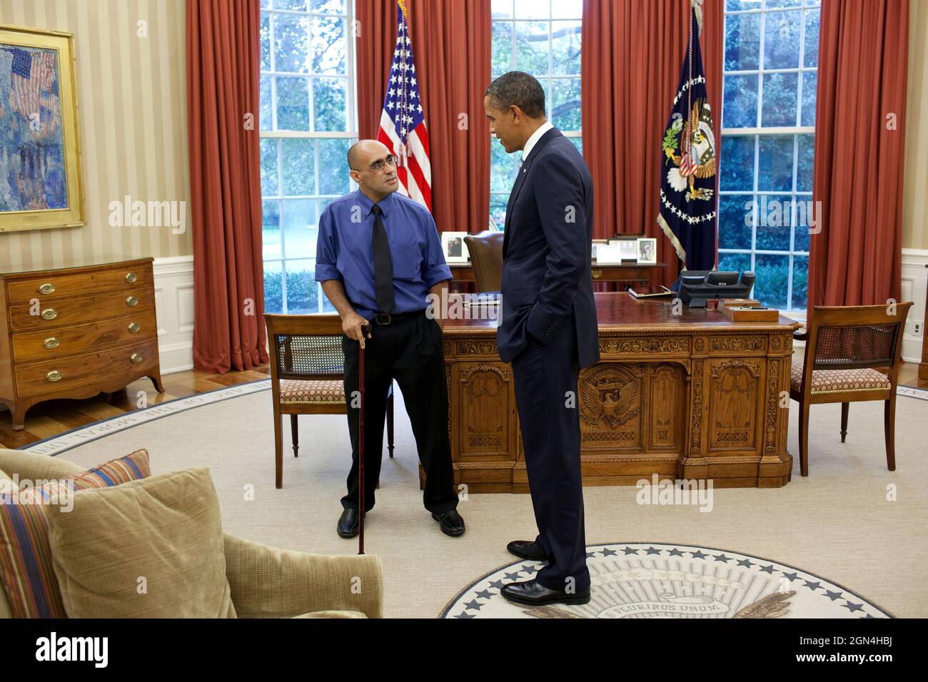 President Barack Obama meets with New York Times photojournalist Joao Silva in the Oval Office, Sept. 15, 2011. Silva lost both his legs when he stepped on a mine while accompanying U.S. soldiers on patrol near the town of Arghandab, in southern Afghanistan, Oct. 23, 2010. (Official White House Photo by Pete Souza) This official White House photograph is being made available only for publication by news organizations and/or for personal use printing by the subject(s) of the photograph. The photograph may not be manipulated in any way and may not be used in commercial or political materials, ad Stock Photo