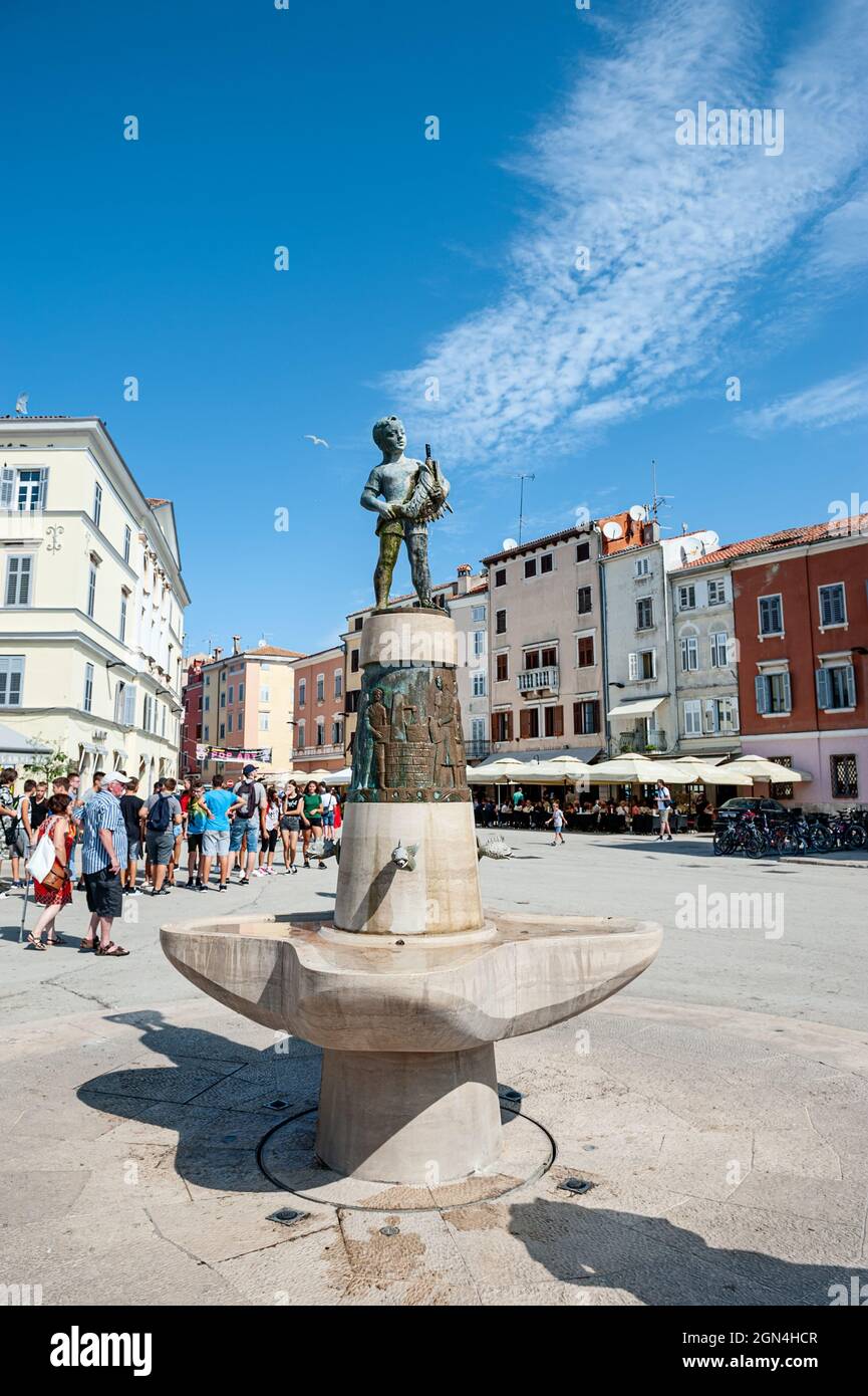 ROVINJ, CROATIA-AUGUST 20, 2018: Fountain with sculpture and Clock Tower on the Picturesque Town Square in Rovinj, Croatia. Stock Photo