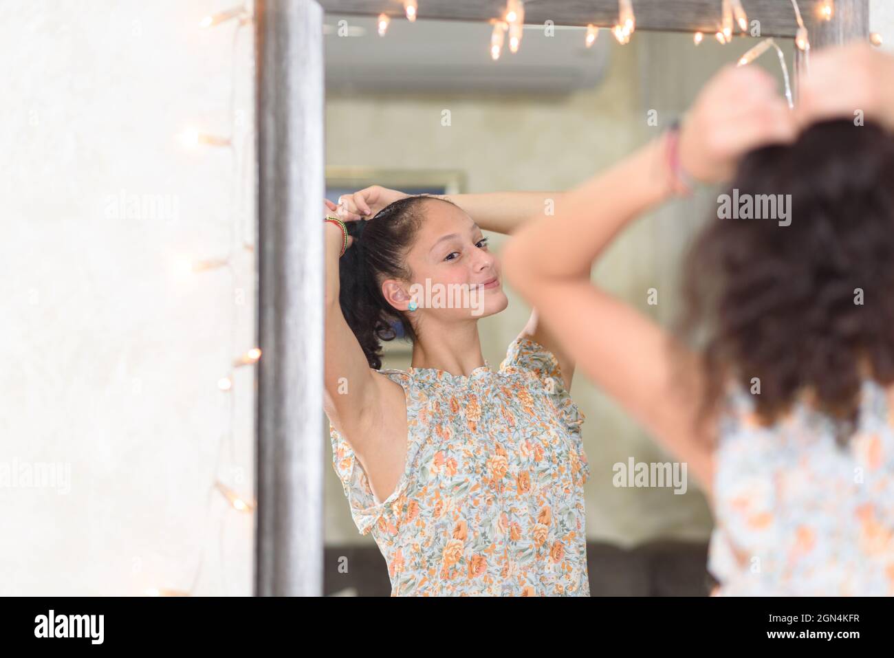 Fizzy Looking Portrait of a teenage girl with frizzy black hair looking at mirror and ...