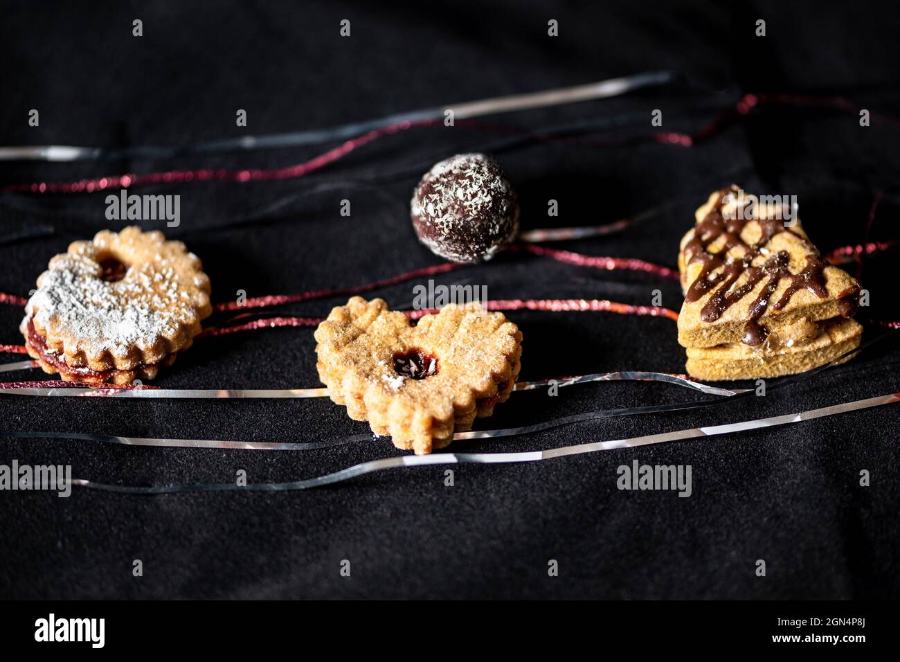 Small christmas cake on black velvet with silver and red thread. Stock Photo