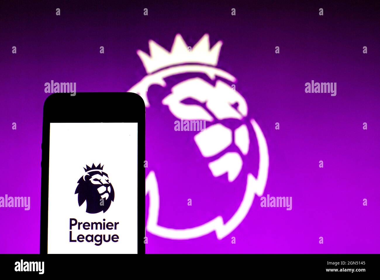 In this photo illustration a Premier League logo seen displayed on a smartphone with a Premier League logo in the background. Stock Photo