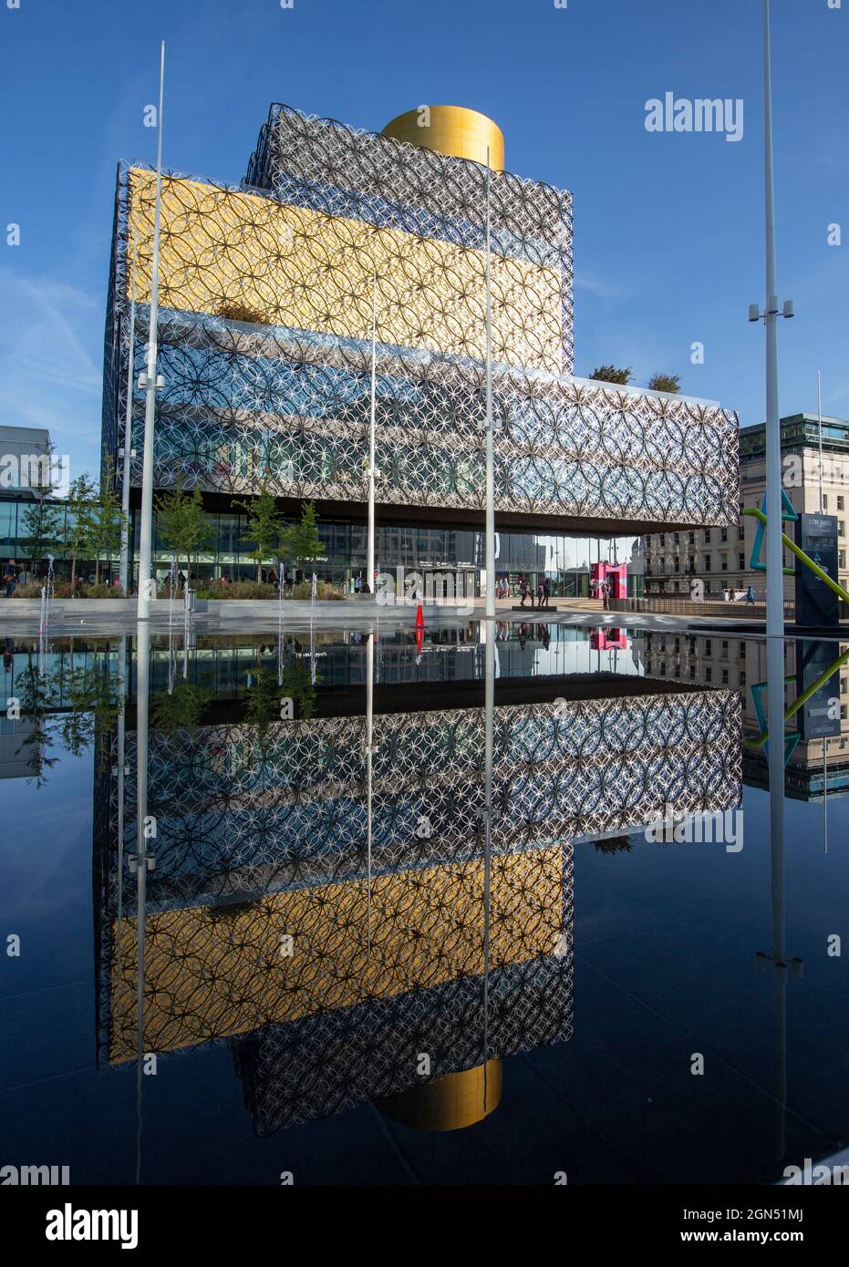 The Library of Birmingham in the autumn sunshine reflected in the water feature in Centenary Square in Birmingham City Centre, UK. Stock Photo