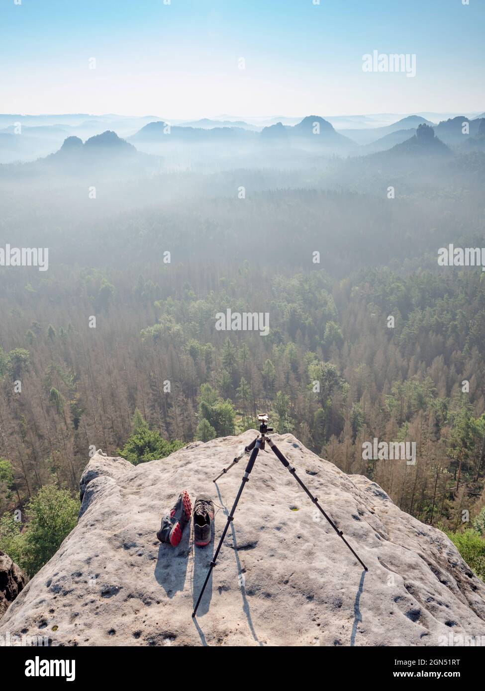 Modern camera lightweight tripod on rocky view point late misty morning