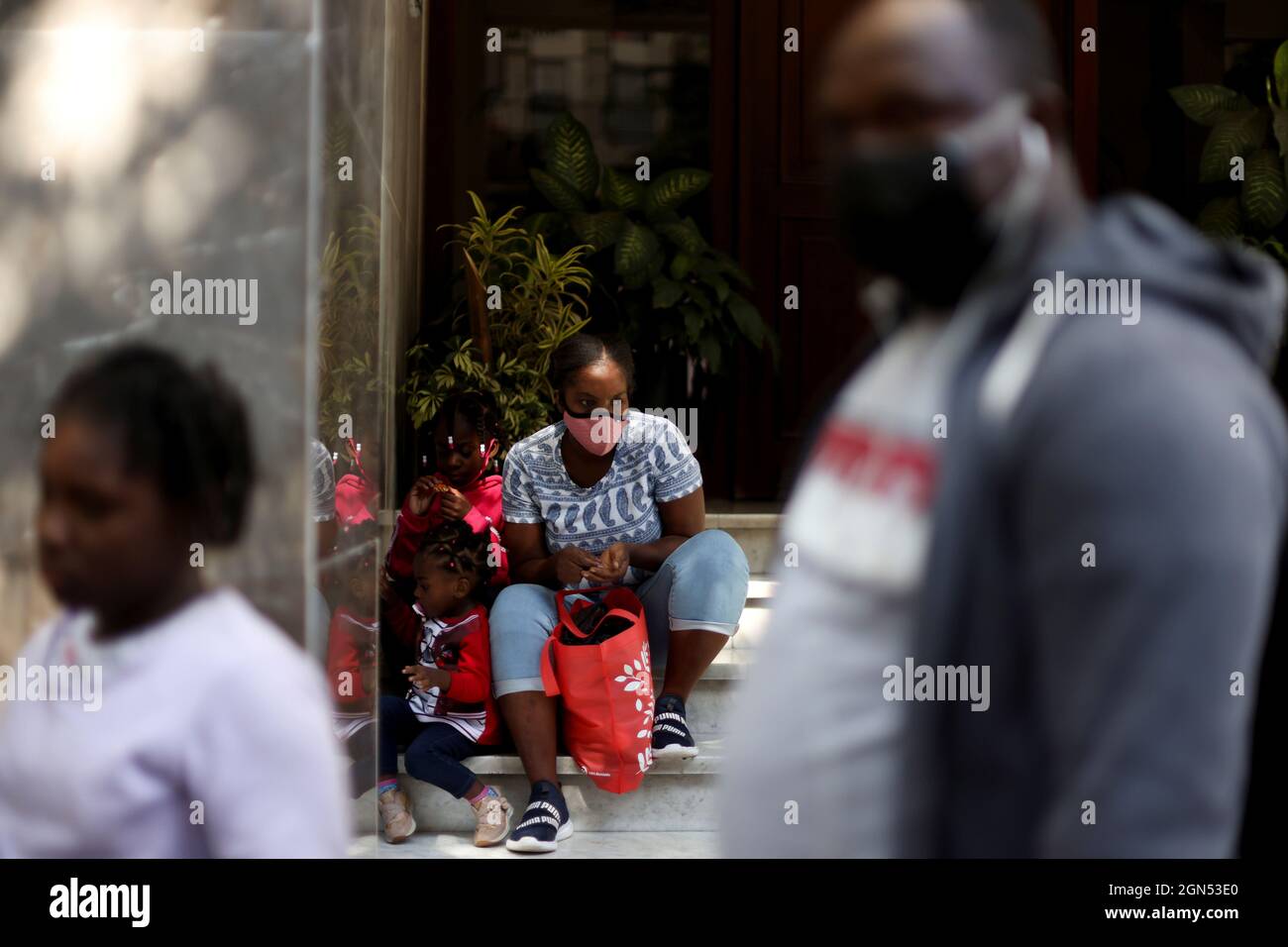 A migrant family from Haiti rests outside of the Mexican Commission for Aid to Refugees (COMAR) after they deliver their documents to regularise their migratory situation, in Mexico City, Mexico September 22, 2021. REUTERS/Edgard Garrido Stock Photo