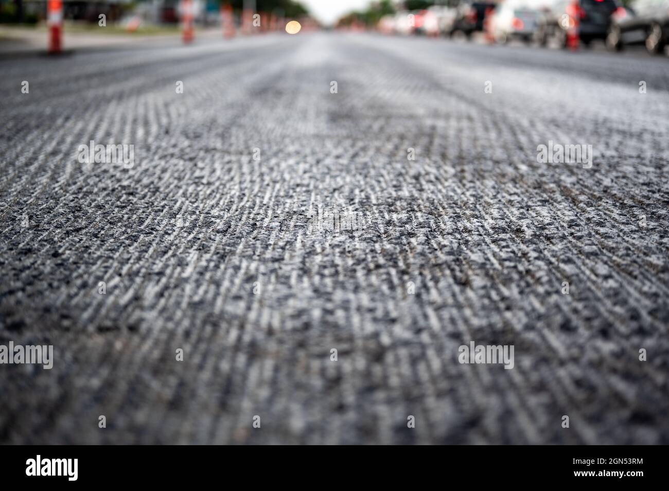 Low angle shot across a scarified street under construction with lanes on either side blocked off. Stock Photo