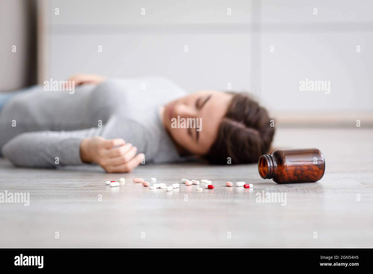 Female with pile of antidepressants kill herself, commit suicide, suffer from mental distress Stock Photo