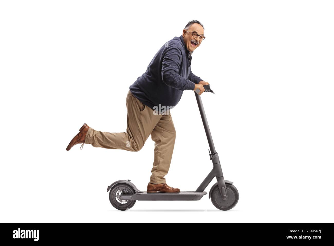 guiden indsigelse forkorte Funny mature man riding an electric scooter and looking at camera solated  on white background Stock Photo - Alamy