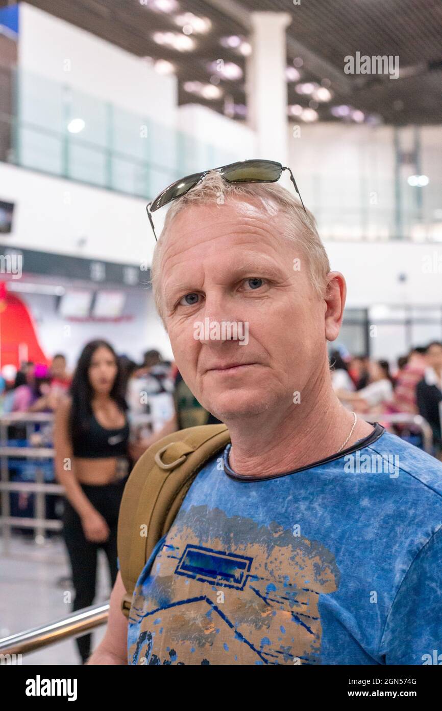 an elderly man at the airport is checking in for a flight Stock Photo