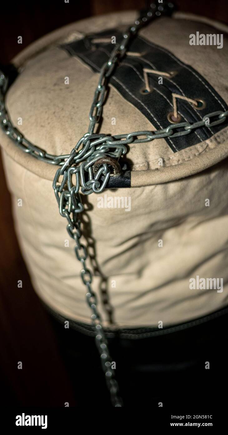 Fight club with old worn vintage leather punching bag for practicing martial arts. Exercising