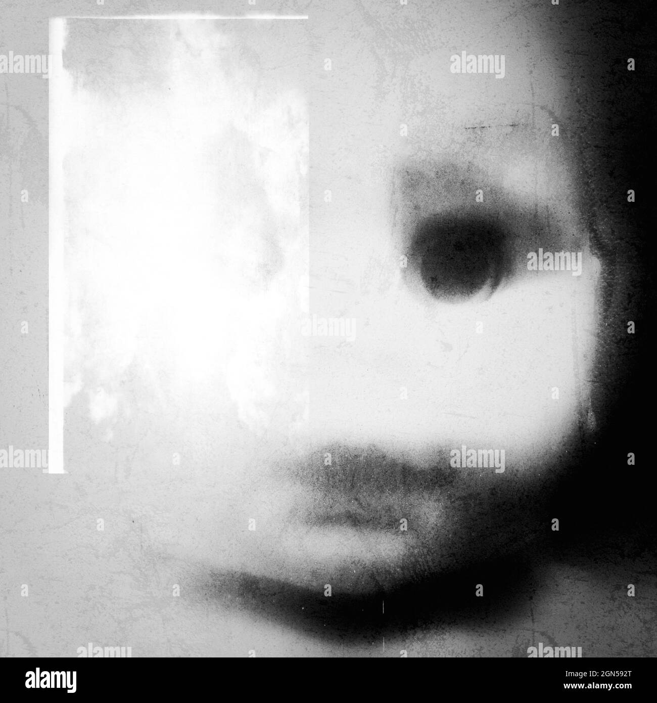 A spooky and disturbing image of a doll on a grunge and old photo effect. Doll head. Surreal doll portrait. Stock Photo