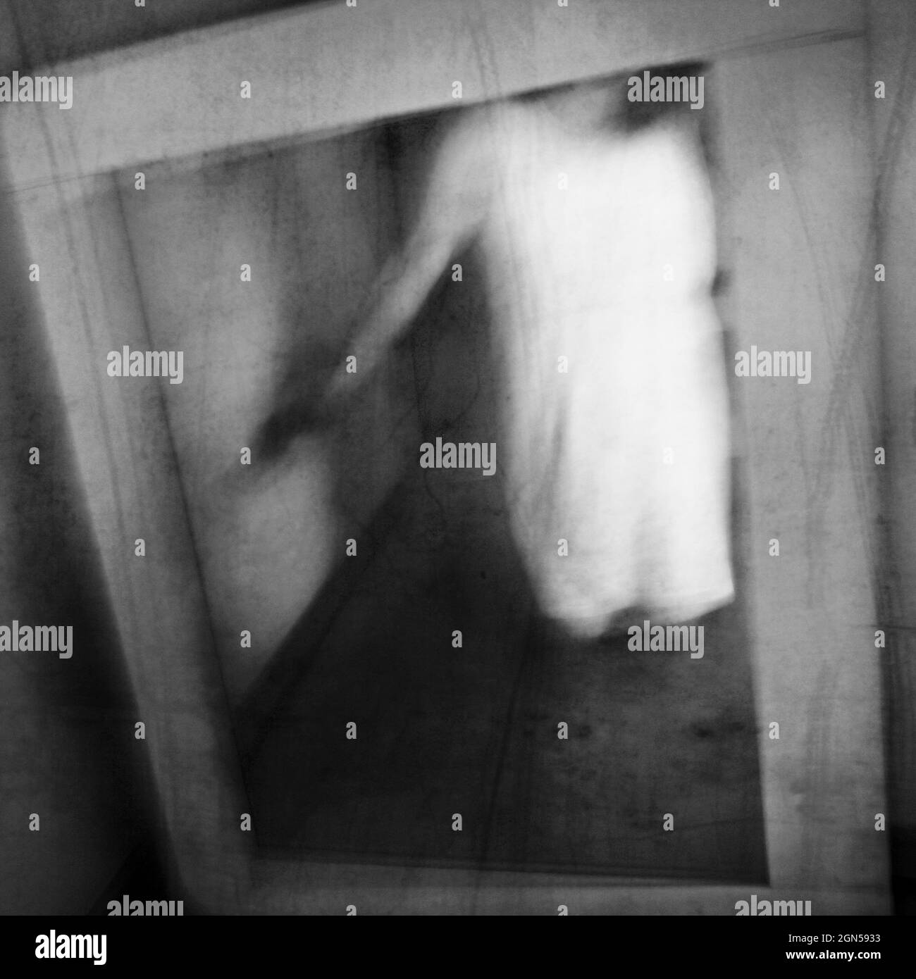 A ghost appears in an old vintage mirror. Phantom apparition. Long exposure. Stock Photo