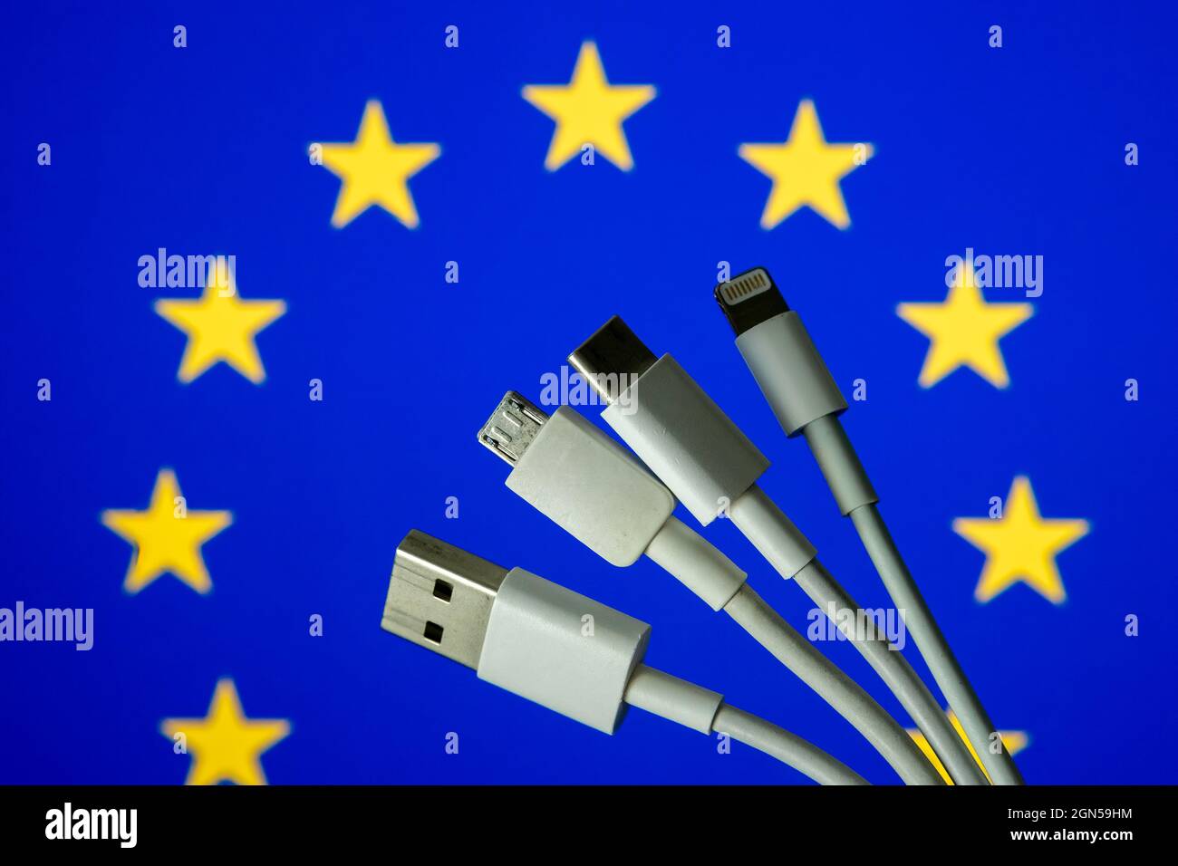 EU flag and different charging cables such as USB, USB-C, Micro USB, lightning cable. Concept for new EU universal charging cable legislation. Stock Photo
