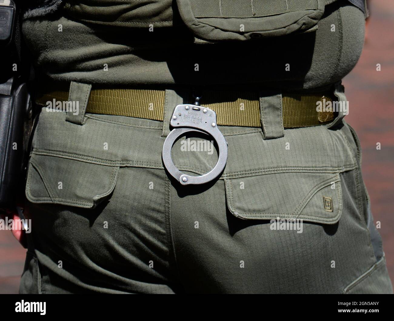 A pair of handcuffs hang from the belt of a member of the Santa Fe, New Mexico Police Department's SWAT team. Stock Photo